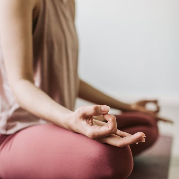 Close-up of a person's hands in a meditative mudra pose.